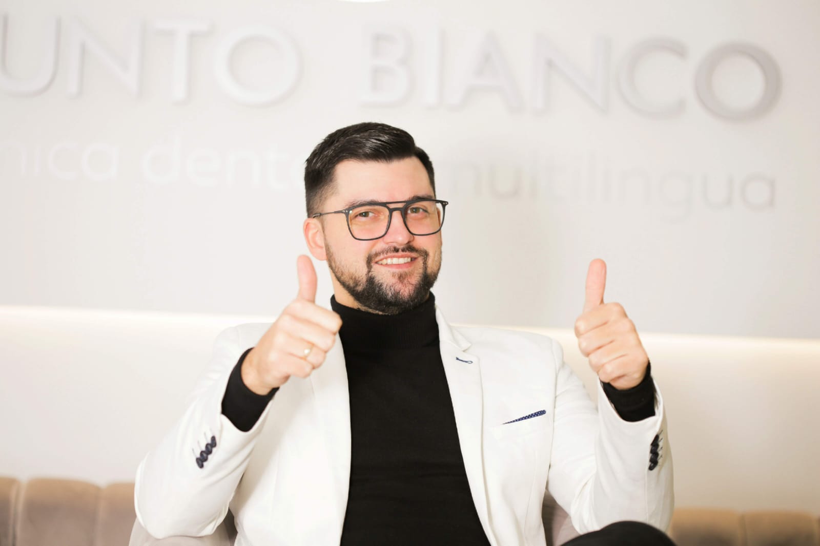 Mihail Ceropita, directorul clinicii Punto Bianco, în fața peretelui cu logo